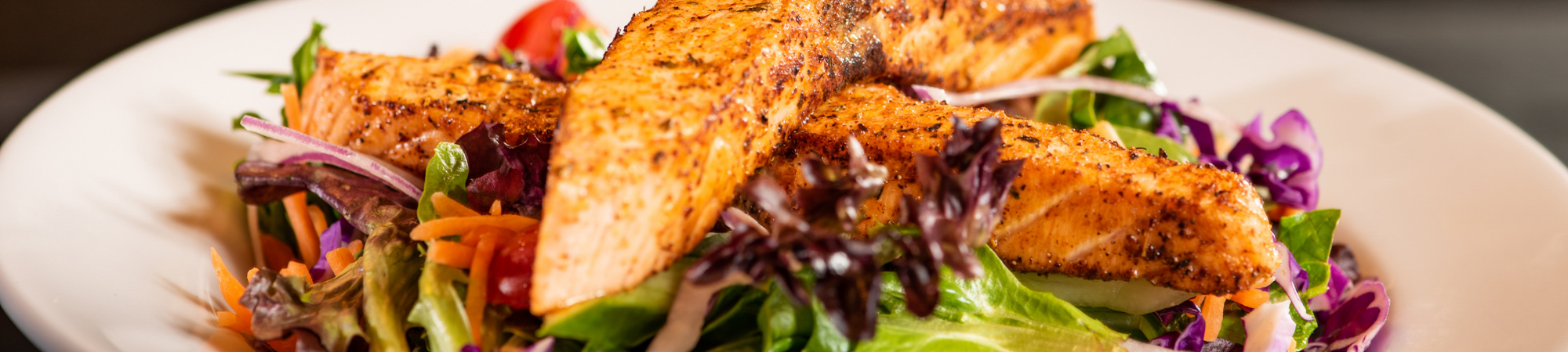 seared fish over a fresh salad 